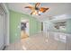 Open-concept living space with tiled floors, ceiling fans, and a view into the kitchen at 3529 Orion Rd, Spring Hill, FL 34606