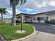 Community clubhouse featuring a well-maintained lawn, ample parking, and attractive landscaping at 3605 100Th N Ter, Pinellas Park, FL 33782