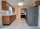 Classic kitchen featuring wood cabinets, white tile floors, and stainless-steel appliances at 3605 100Th N Ter, Pinellas Park, FL 33782
