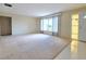 Bright, expansive living room with neutral carpeting and natural light entering through the front door and window at 3605 100Th N Ter, Pinellas Park, FL 33782