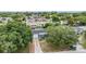 Aerial view of a gray home with a driveway, nestled among lush trees in a quiet neighborhood at 3625 Oakhurst Dr, Holiday, FL 34691