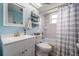 Clean bathroom with white vanity, toilet, shower and white and gray shower curtain at 3625 Oakhurst Dr, Holiday, FL 34691