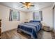 Cozy bedroom with hardwood floors, natural light from two windows and a comfortable striped blue comforter at 3625 Oakhurst Dr, Holiday, FL 34691
