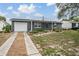 A single-story home featuring a well-manicured front yard and a welcoming front door at 3625 Oakhurst Dr, Holiday, FL 34691