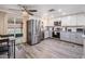 Modern kitchen with stainless appliances, hardwood flooring, gray cabinets, and sliding door to the patio at 3625 Oakhurst Dr, Holiday, FL 34691