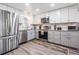 Well-lit kitchen with stainless steel appliances, and granite countertops and white and gray cabinets at 3625 Oakhurst Dr, Holiday, FL 34691
