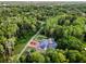 Aerial view of the property nestled in a serene, wooded area, featuring a pool and charming home at 3663 Berger Rd, Lutz, FL 33548