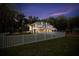 Charming two-story home featuring a well-lit exterior, white picket fence, and a beautifully landscaped yard at 3663 Berger Rd, Lutz, FL 33548