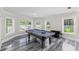 Spacious game room with a pool table, marble floors, and natural light from multiple windows at 3663 Berger Rd, Lutz, FL 33548