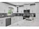 Contemporary kitchen featuring marble counters, white cabinets, stainless steel appliances, and tile backsplash at 3663 Berger Rd, Lutz, FL 33548
