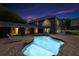 Inviting backyard pool with brick patio, lounge chairs, and a glimpse of the home's well-lit interior at 3663 Berger Rd, Lutz, FL 33548