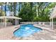 In-ground pool surrounded by brick pavers, a covered bar area, and lush landscaping at 3663 Berger Rd, Lutz, FL 33548