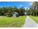Outdoor shed on a spacious lot with lush green grass and mature trees, offering ample storage at 3663 Berger Rd, Lutz, FL 33548