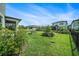 Expansive backyard with lush lawn, mature landscaping, and black metal fence at 4608 Emprise Way, Land O Lakes, FL 34638