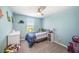 bedroom with blue walls, carpeted floor, ceiling fan, and a cozy bed featuring dinosaur decor at 4608 Emprise Way, Land O Lakes, FL 34638