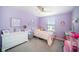 bedroom with lilac walls, carpeted floor, ceiling fan, and a cozy bed featuring flower decor at 4608 Emprise Way, Land O Lakes, FL 34638