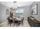 Dining room features a modern chandelier, a gray accent wall, and window views at 4608 Emprise Way, Land O Lakes, FL 34638