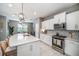 Open kitchen boasts stainless steel appliances, a spacious island, and modern light fixtures at 4608 Emprise Way, Land O Lakes, FL 34638