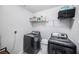 Modern laundry room with updated washer and dryer and wire shelving for ample storage at 4608 Emprise Way, Land O Lakes, FL 34638