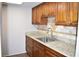 Galley kitchen featuring tile backsplash, light countertops and wood cabinets at 4702 Michael Ct # 139, Tampa, FL 33614