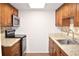 Galley kitchen with stainless steel appliances, light countertops and wood cabinets at 4702 Michael Ct # 139, Tampa, FL 33614