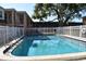Community pool, surrounded by white fencing, with building and landscaping views at 4702 Michael Ct # 139, Tampa, FL 33614
