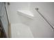 Bright white tiled shower with built-in corner shelf and grab bar at 4702 Michael Ct # 139, Tampa, FL 33614