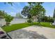 Spacious backyard featuring artificial turf, a concrete patio, and lush tropical landscaping at 4704 W Fairview Hts, Tampa, FL 33616