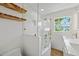 Modern bathroom with frameless glass shower, wood shelving, and updated vanity with brass hardware at 4704 W Fairview Hts, Tampa, FL 33616