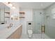 Modern bathroom showcasing a glass shower, floating shelves, and herringbone tile flooring at 4704 W Fairview Hts, Tampa, FL 33616