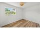 Clean, empty bedroom with wood-look floors, a woven-look light fixture and a sun-lit window at 4704 W Fairview Hts, Tampa, FL 33616