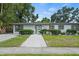 Charming single-story home featuring a well-maintained lawn, mature trees, and a welcoming walkway at 4704 W Fairview Hts, Tampa, FL 33616
