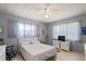 Bedroom with a bed, fan, and two windows dressed with curtains on a neutral-colored floor at 5391 54Th N St, St Petersburg, FL 33709