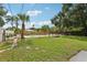 Large backyard with a pool area, lush lawn, and mature palm trees at 6 N Orion Ave, Clearwater, FL 33765