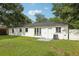 Spacious backyard with green lawn, white exterior, and modern air conditioning unit at 6 N Orion Ave, Clearwater, FL 33765