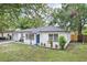 Charming single-story home with white exterior, blue front door, well-manicured lawn, and nicely landscaped front garden at 6 N Orion Ave, Clearwater, FL 33765