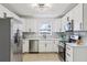 Bright kitchen with white cabinetry, stainless steel appliances, modern lighting, and stylish backsplash at 6 N Orion Ave, Clearwater, FL 33765