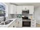 Modern kitchen with white cabinets, stainless steel appliances, and sleek countertops at 6 N Orion Ave, Clearwater, FL 33765