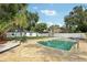 Backyard featuring a large pool, patio area, mature trees, and a well-maintained lawn at 6 N Orion Ave, Clearwater, FL 33765