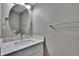 Half-bathroom featuring modern vanity, white bowl sink, granite countertop, brushed metal faucet, and an oval mirror at 6601 121St Ave # I, Largo, FL 33773