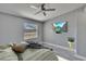 Bright bedroom with ceiling fan, wood-look floors, and a large window for natural light at 6601 121St Ave # I, Largo, FL 33773