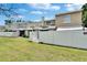 View of back exterior of the townhome, with white fenced in yards and green lawn at 6601 121St Ave # I, Largo, FL 33773
