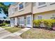 Charming townhome with manicured lawn, vibrant shrubs, and inviting front entrance at 6601 121St Ave # I, Largo, FL 33773