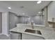 Bright eat-in kitchen features stainless steel sink, faucet, granite countertops and modern cabinetry at 6601 121St Ave # I, Largo, FL 33773