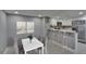 Modern kitchen with stainless steel appliances, white cabinets, and breakfast bar seating at 6601 121St Ave # I, Largo, FL 33773