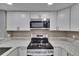 Modern kitchen features stainless steel appliances, granite countertops and white cabinets with sleek hardware at 6601 121St Ave # I, Largo, FL 33773