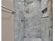 A spacious shower with blue marble tile and pebble flooring, as well as recessed shelving at 6601 121St Ave # I, Largo, FL 33773