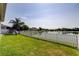 Spacious backyard featuring a white picket fence, play set, and stunning lake view, perfect for outdoor enjoyment at 6648 Castle Green Pl, Zephyrhills, FL 33541