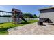 Backyard with a playset, green grass and partial view of a lake at 6648 Castle Green Pl, Zephyrhills, FL 33541