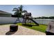 Backyard with a playset, green grass and a view of a lake at 6648 Castle Green Pl, Zephyrhills, FL 33541